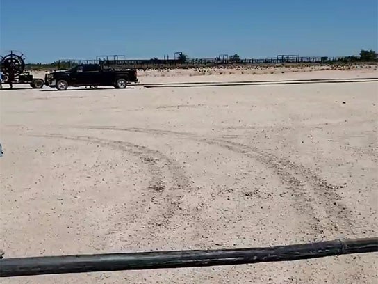 Large open white dirt field with tire tracks.