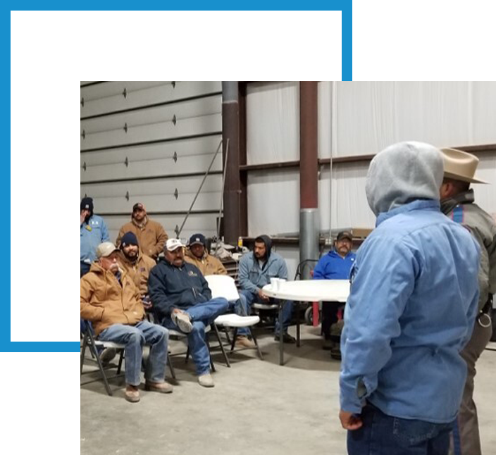 3G Construction employees sitting in a meeting in a warehouse.