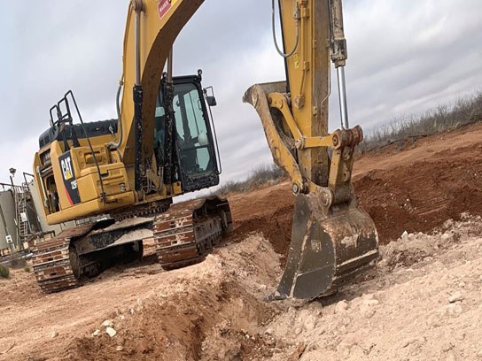 Dramatic close up of a caterpillar heavy machine about to dig up dirt.