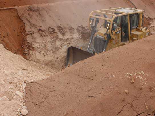 Caterpillar digging inside a large pit of dirt.