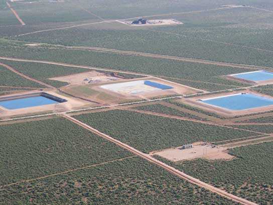 Aerial view of several large pits filled with water.