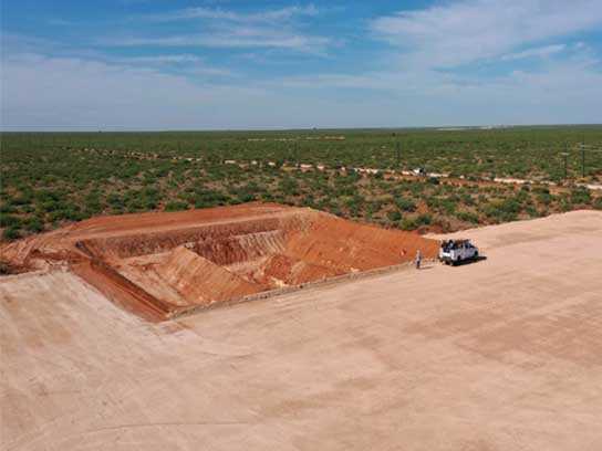 Large dirt pit with trenches in the middle.