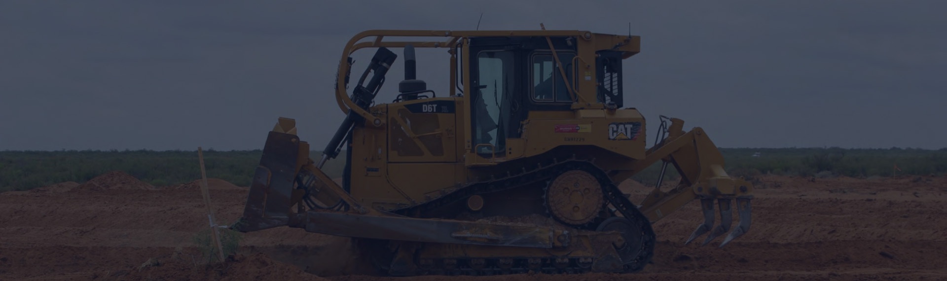 Piece of yellow Cat branded heavy machinery digging in the dirt.